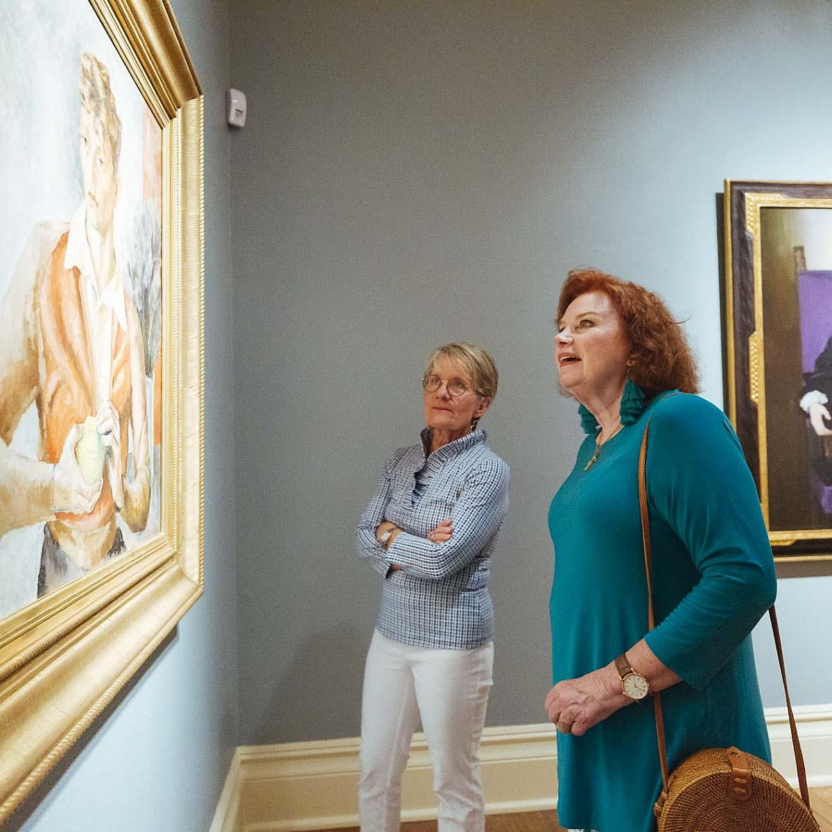 Two women looking at a painting in the Dixon galleries