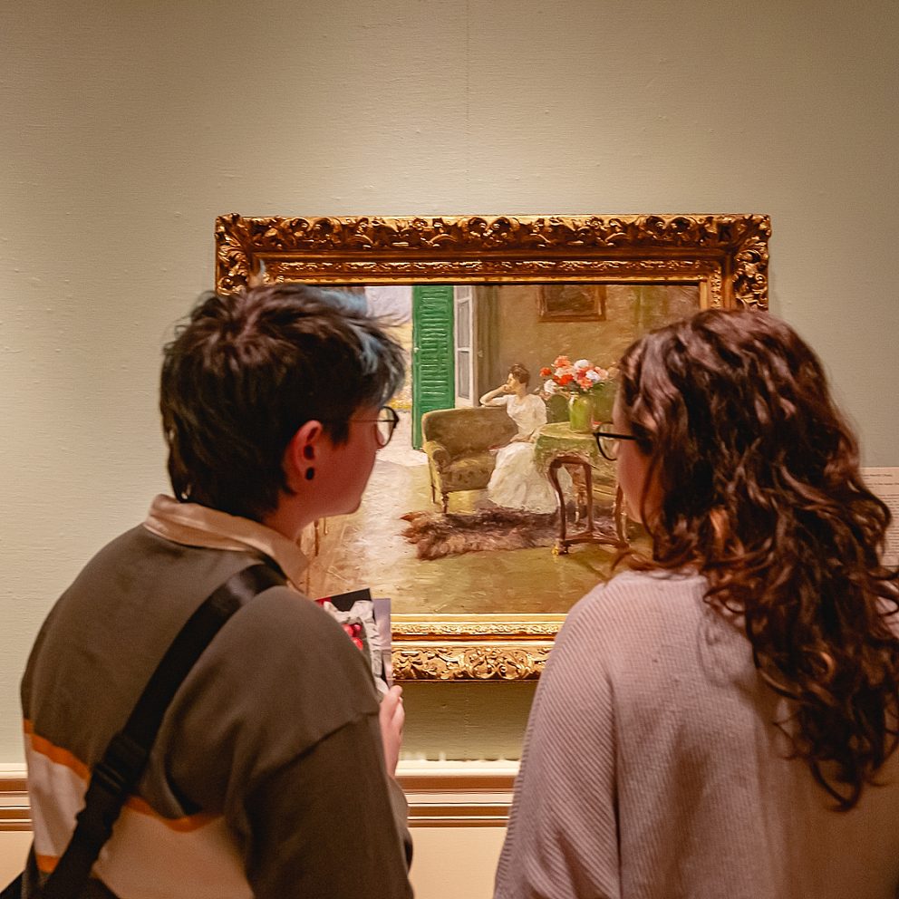 two dixon members looking at artwork of woman sitting in chair