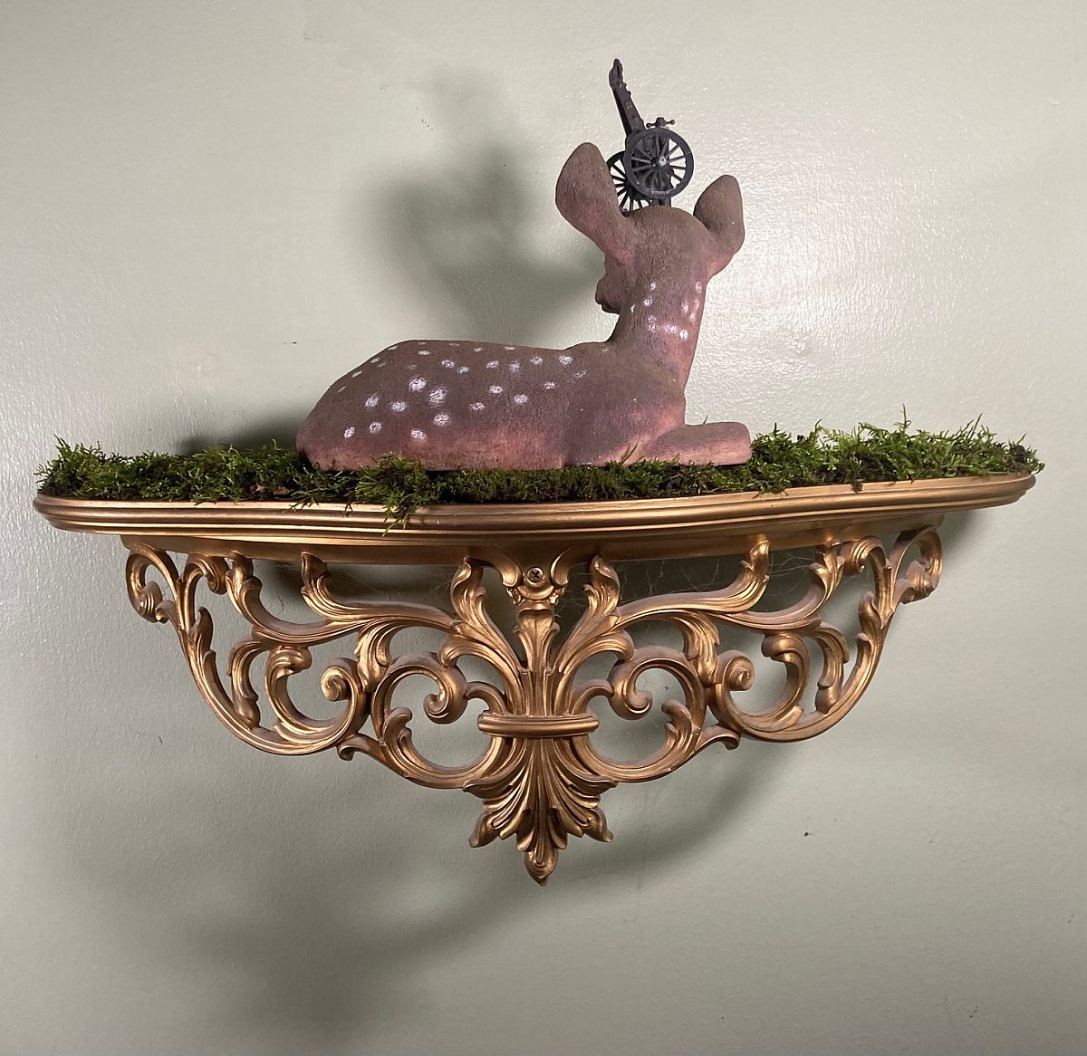 J Clay (Joseph Lee Clayton), "TBMC (Trauma Based Mind Control)," 2024; Plastic deer, cannon pencil sharpener, found moss from forest, and resin shelf; Courtesy of the artist
