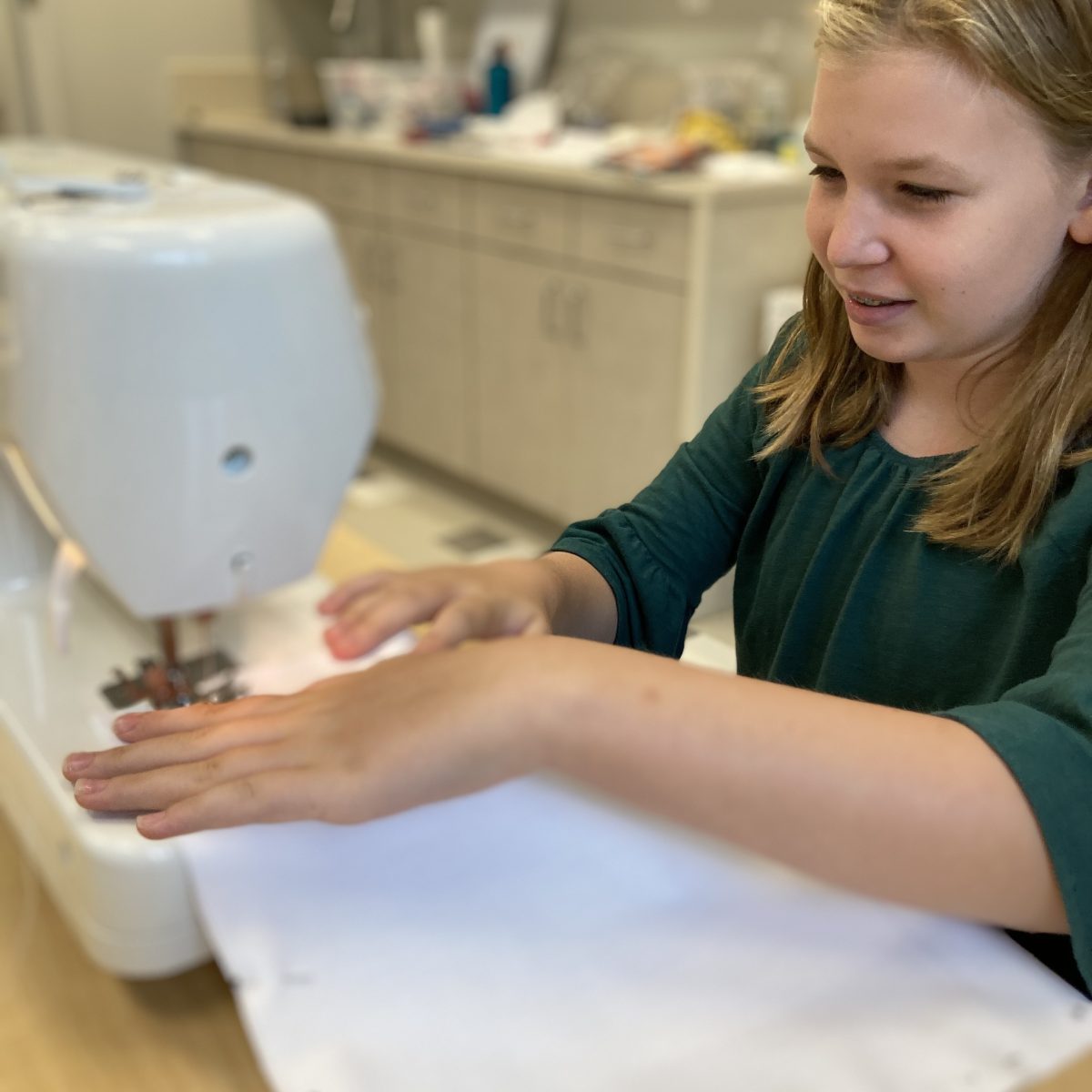 little girl practicing with sewing machine
