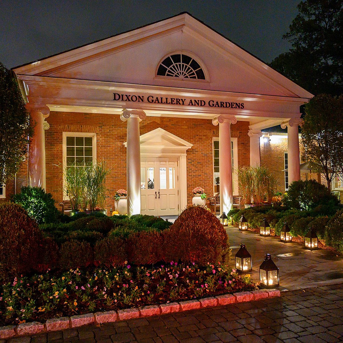 the museum's entrance at night, lit by lanterns lining the walkway