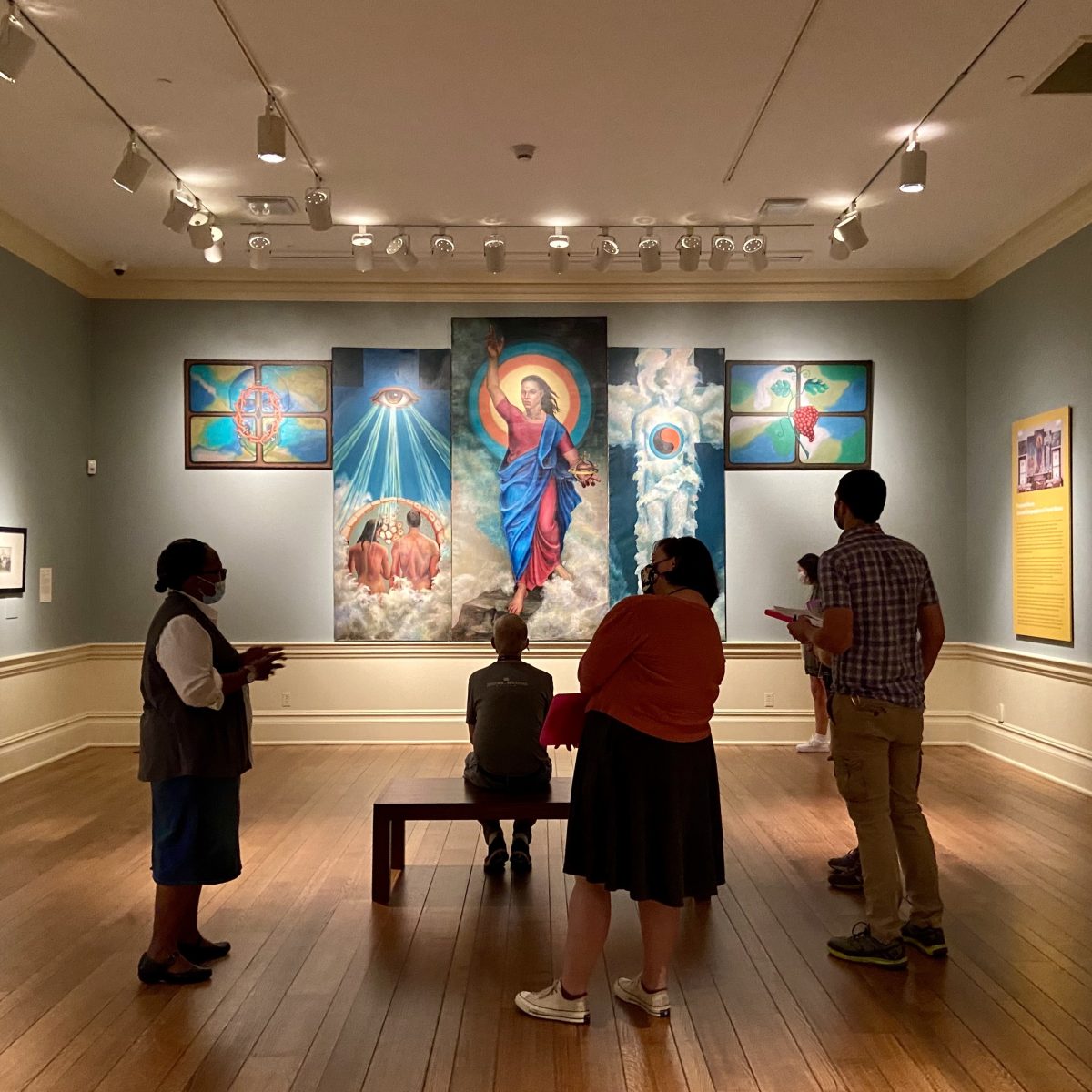 A small tour group being led by a docent to view the Black Artists in America Exhibition