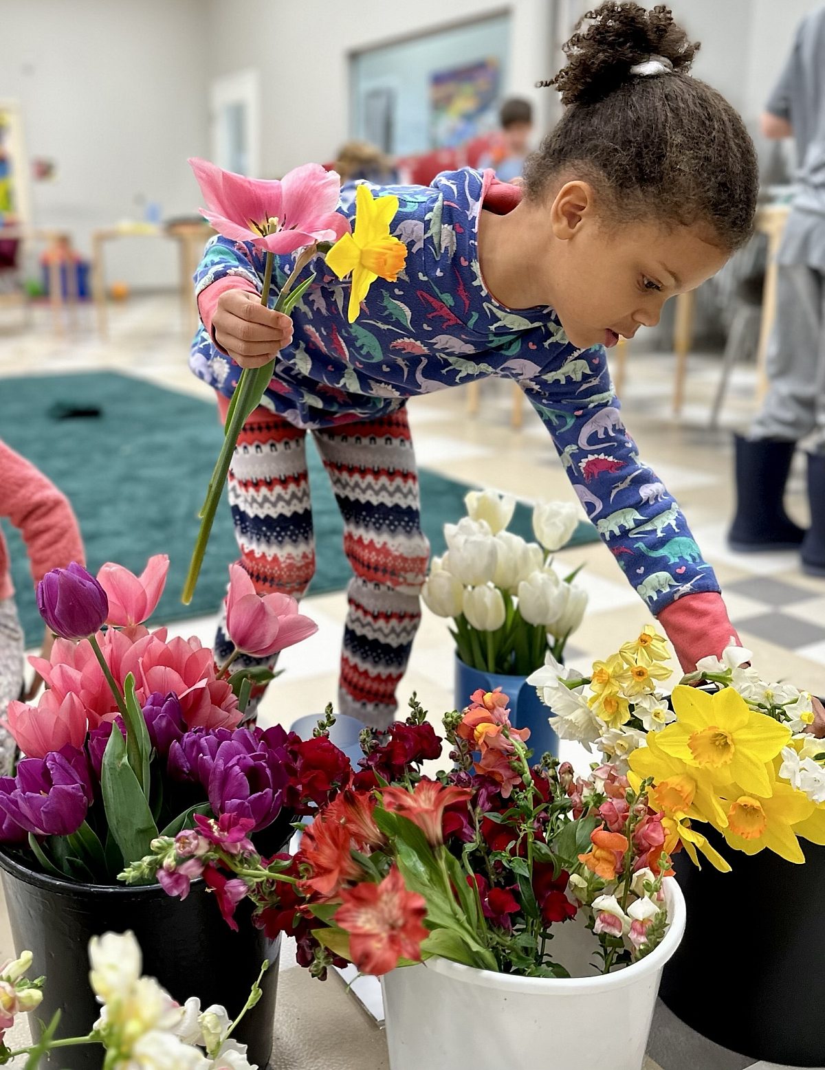 two kids drawing on colorful clipboards in garden, sitting on brick wall