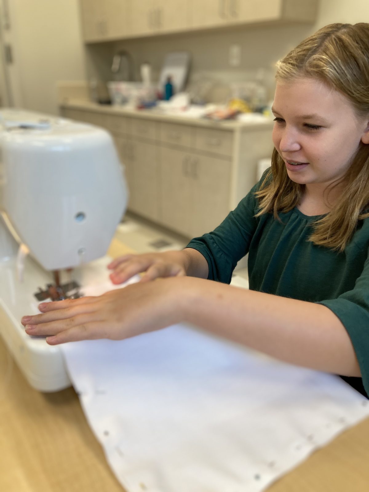 little girl practicing with sewing machine