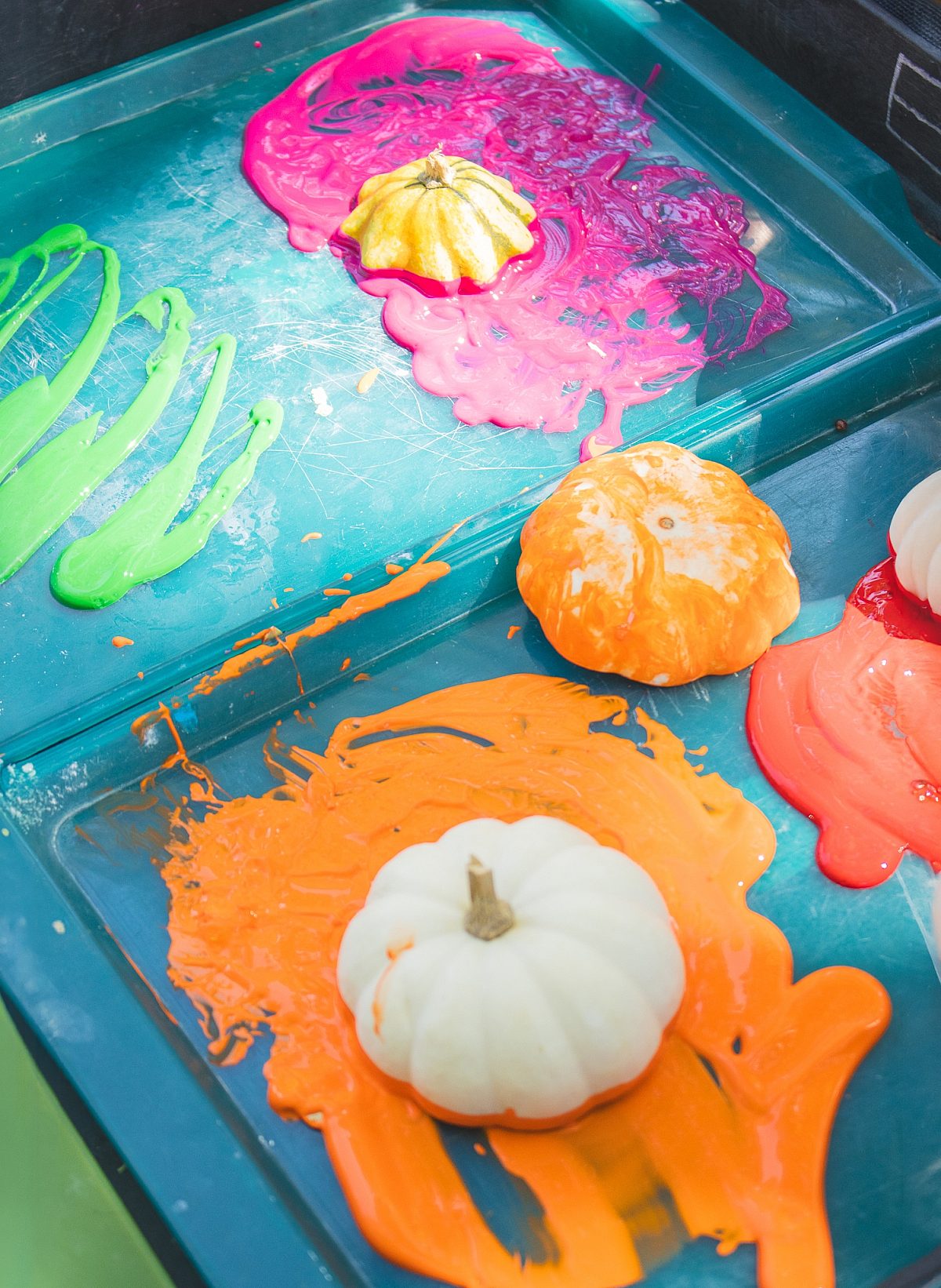 Pumpkins being painted various colors