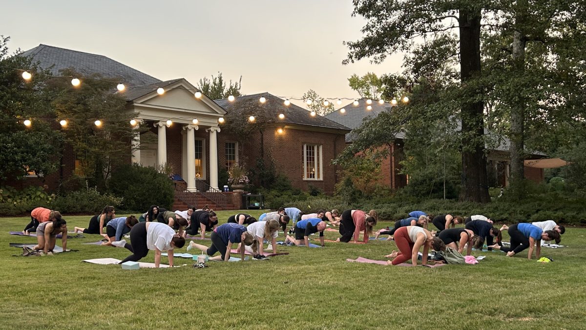 people doing Yoga on the south lawn with lights set up for art on fire