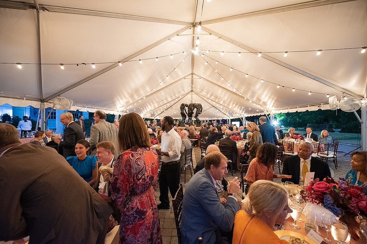 people under tent and sitting at tables