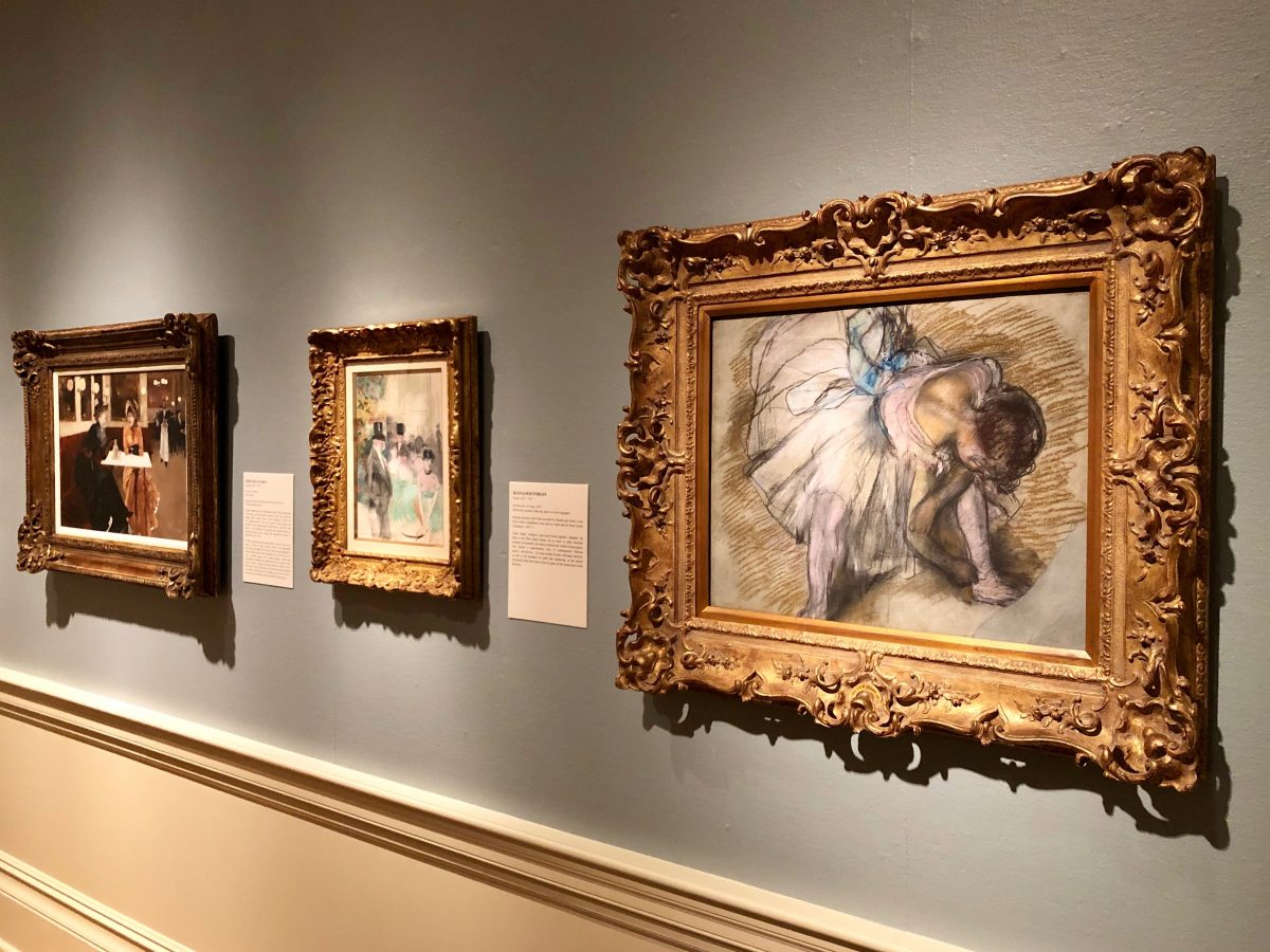 paintings on light blue gallery walls