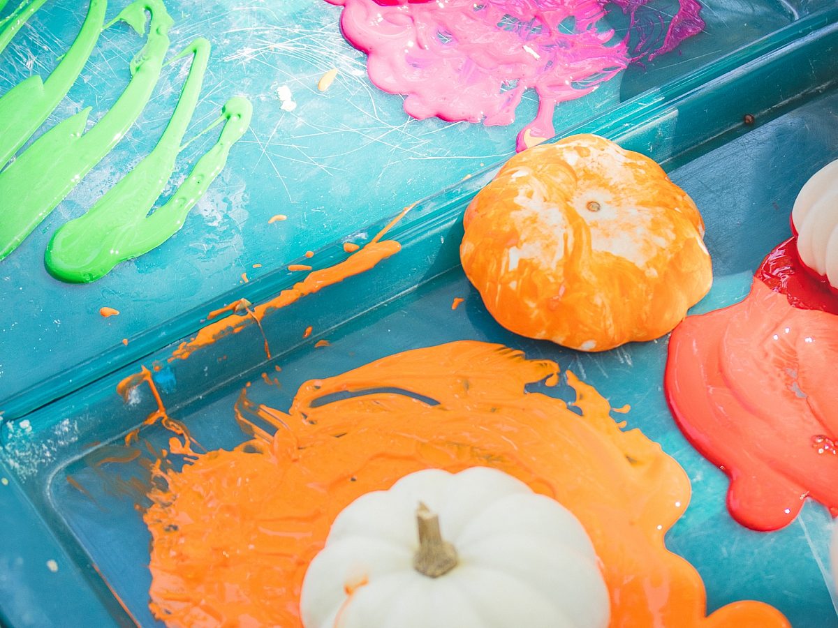 Pumpkins being painted various colors