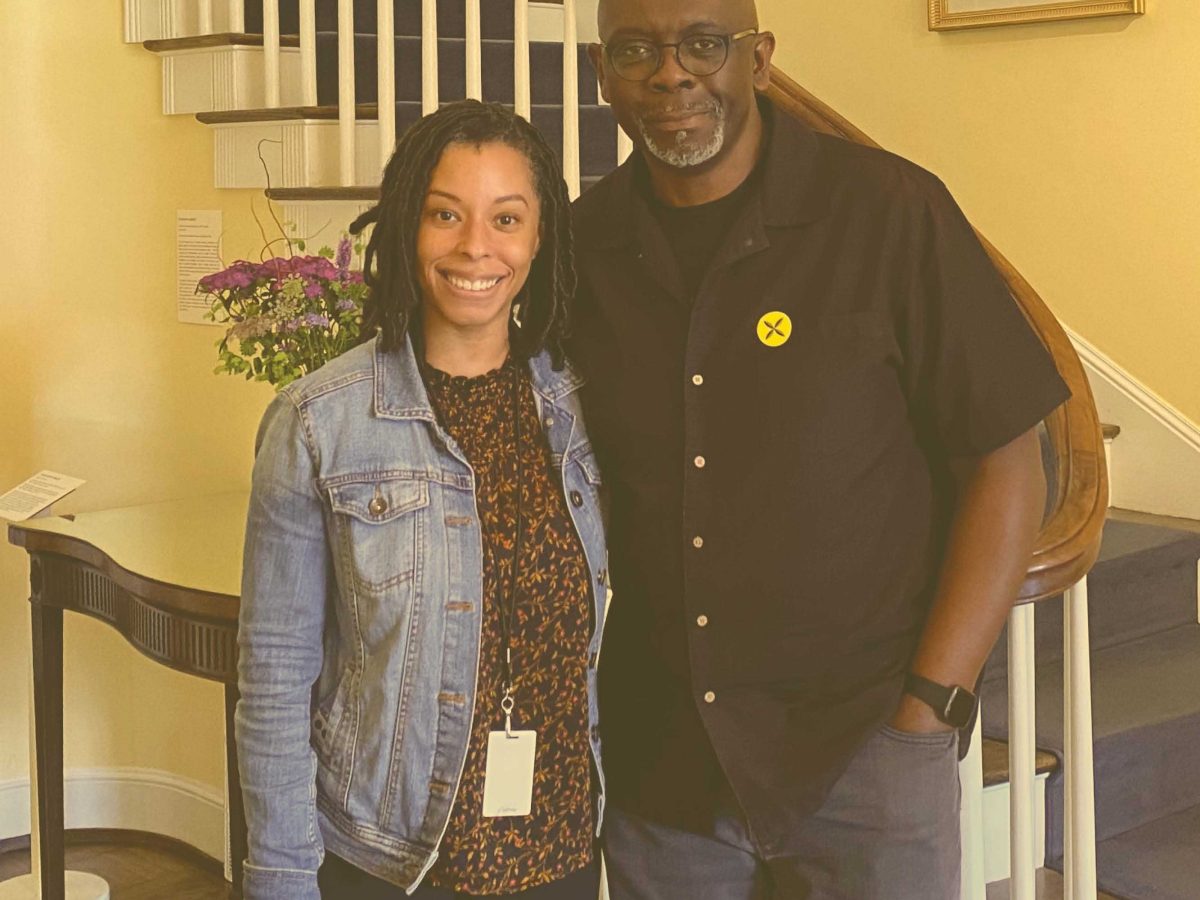 woman and tall man standing in front of dixon residence staircase, square photo with a yellow tint