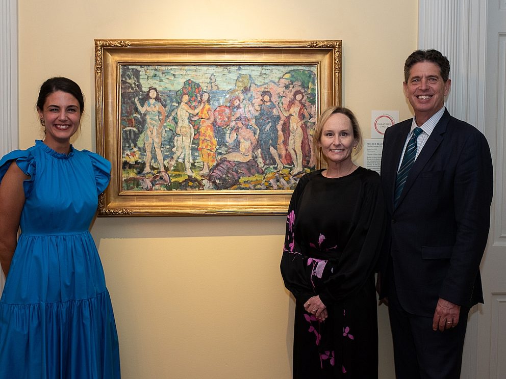 three people standing in front of colorful artwork